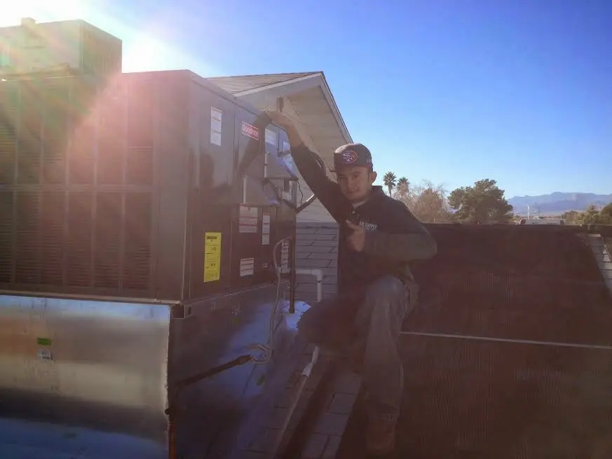 HVAC technician performing Air Duct Cleaning on a rooftop unit in Parma
